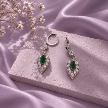 Silver drop earrings with green stones on purple satin