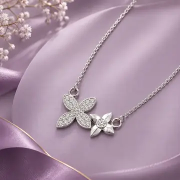 Silver necklace with a flower-shaped pendant on purple satin